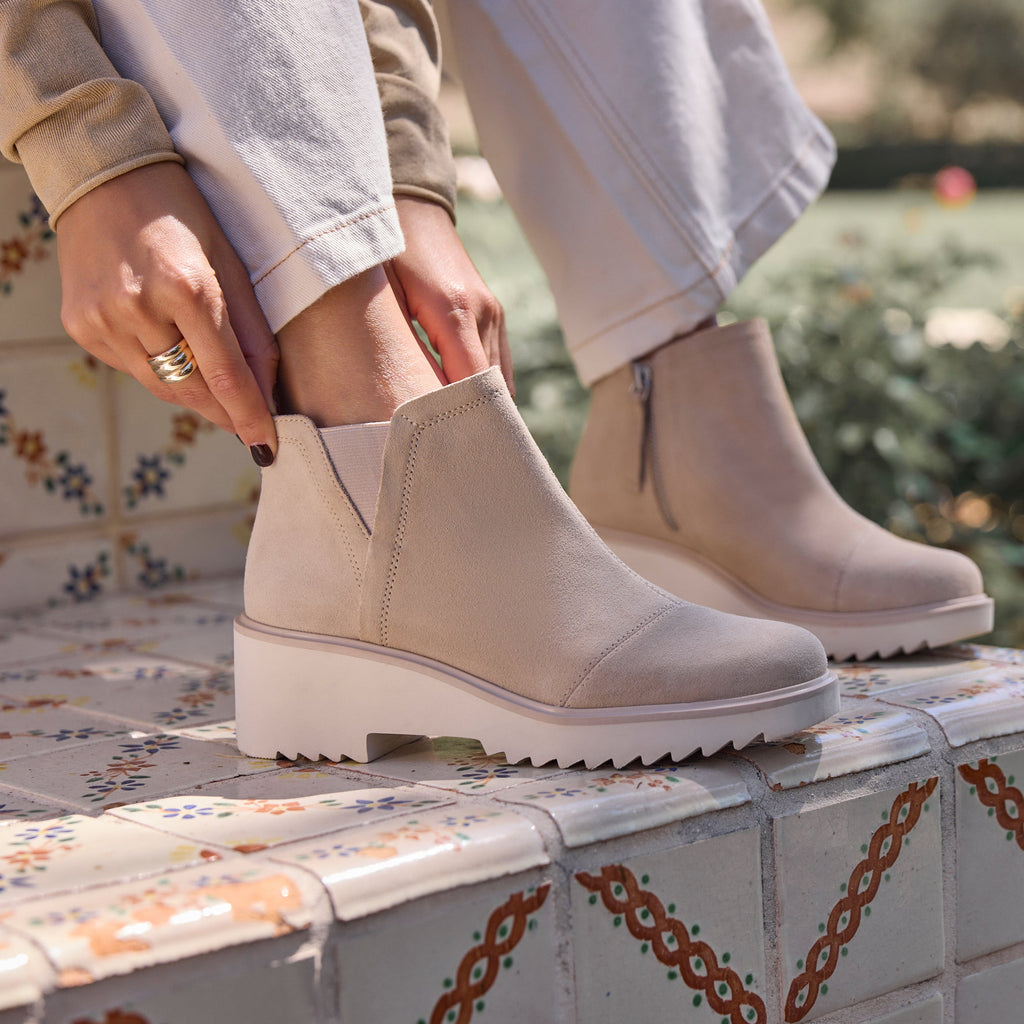 On figure image of the oatmeal suede Maude wedge bootie
