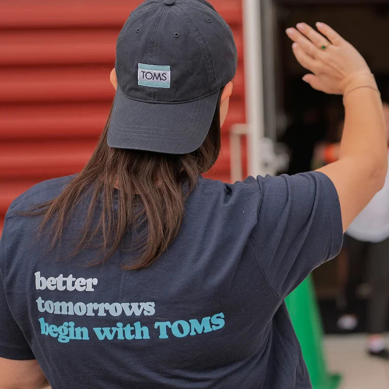 TOMS Team member wearing shirt "better tomorrows begin with TOMS".