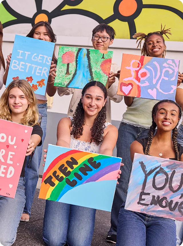 Teenagers holding paintings from Didi Hirsch Mental Health Services.
