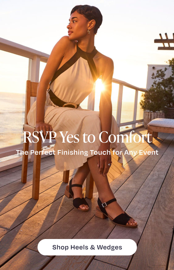 RSVP Yes to Comfort. The Perfect Finishing Touch for Any Event. Shop Heels & Wedges: model wearing Eloise Sandal in Black Woven, beach & sunset background.