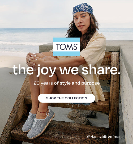TOMS logo. the joy we share. Celebrating 20 years of style and purpose with tastemaker Hannah Bronfman and family. Shop the Anniversary Collection. Caption: with @HannahBronfman. Hannah sitting. Beach background.