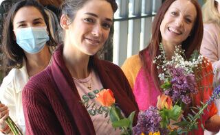 People holding floral bouquets.