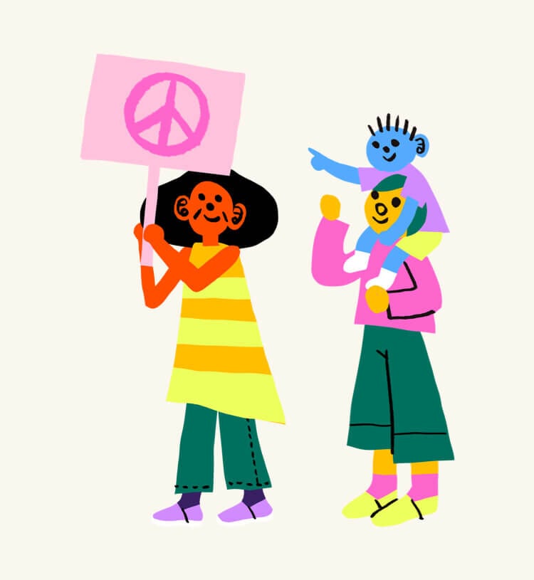 A person holding a sign with a peace sign drawn onto it. Another person with a child on their shoulders pointing to the sign.