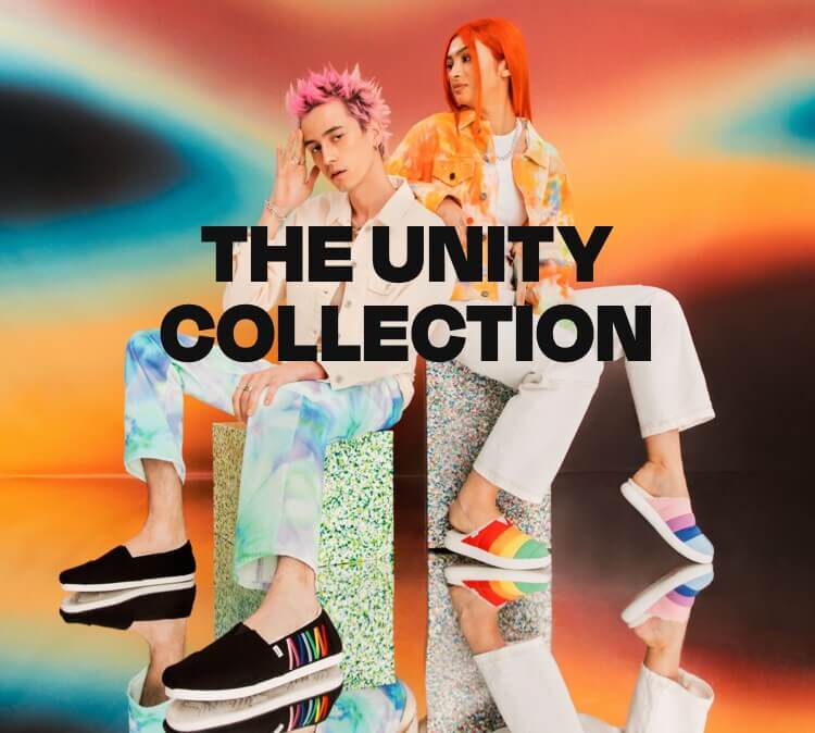 The Unity Collection. Models wearing the men's black Unity Alpargata Espadrille with rainbow bar embroidery and the women's rainbow Unity Mallow Mule.