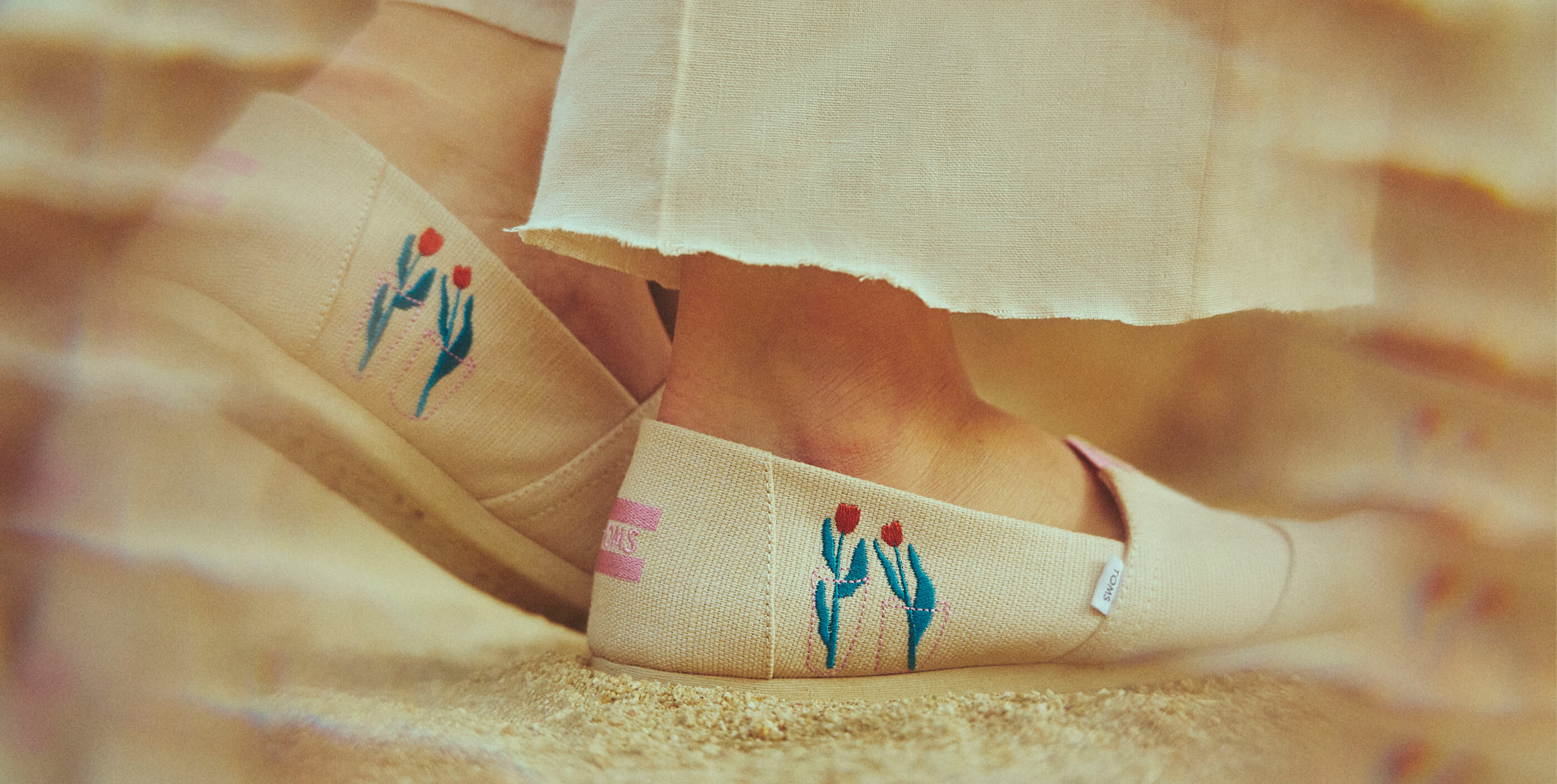 Cropped feet view of model wearing the TOMS X Ludi Leiva Alpargata in Natural shown.