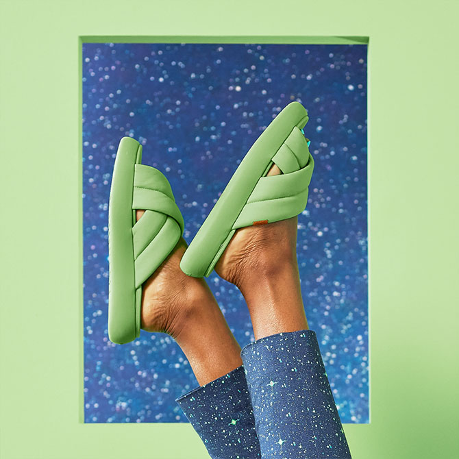 Cropped feet view of model wearing the TOMS X Wildfang Mallow Crossover in arcadian green and the TOMS x WILDFANG Navy Orbits Print Stretch Cotton Twill Crop Pant shown.
