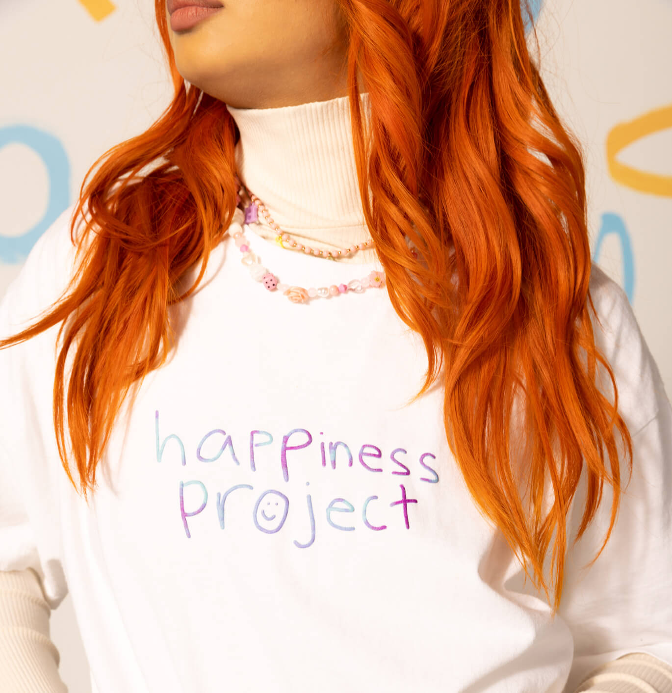 Model wearing TOMS X Happiness Project hoodie shown.